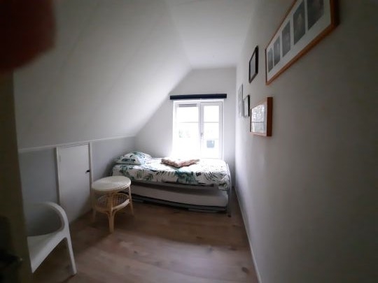 kleine slaapkamer met bed en onderschuifbed.
